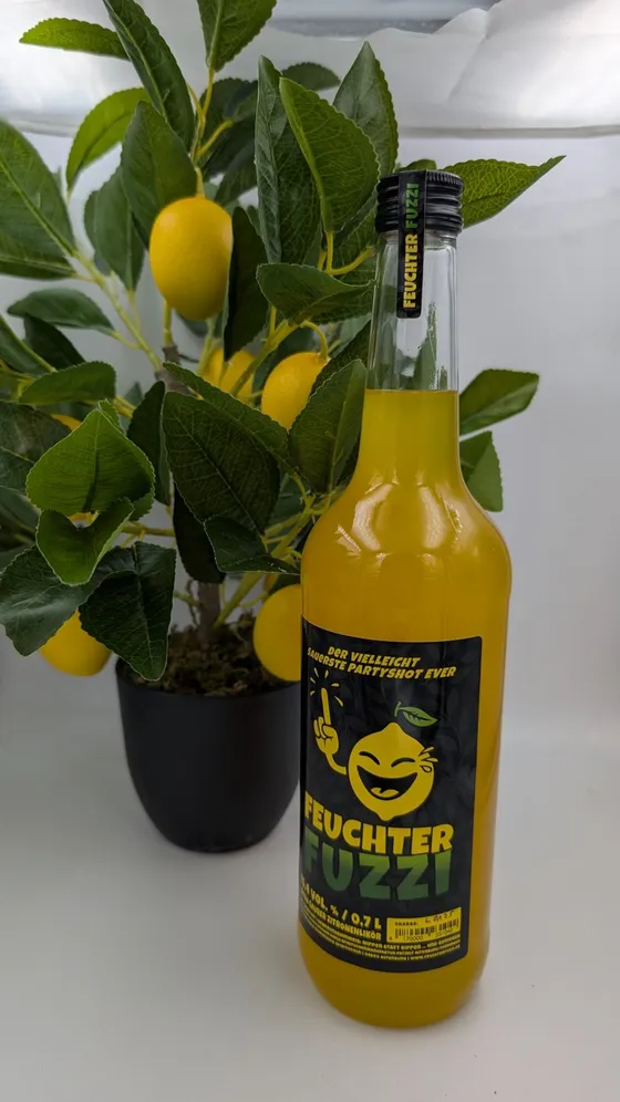 Flasche neben einem Zitronenbäumchen mit gelben Früchten