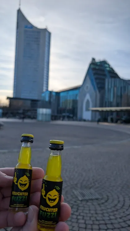 Zwei Fläschchen vor einem Hochhaus und einer Kirche